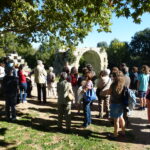 Groupe d'une vingtaine de personnes écoutant le guide devant le pont romain